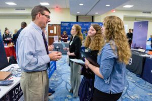 A man giving information about the job to two girls