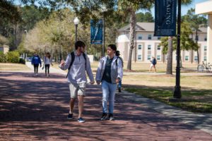 Two boys walking around campus and talking to each other