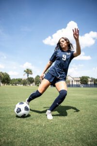 A girl from the Women's soccer team (number 9) shooting the ball