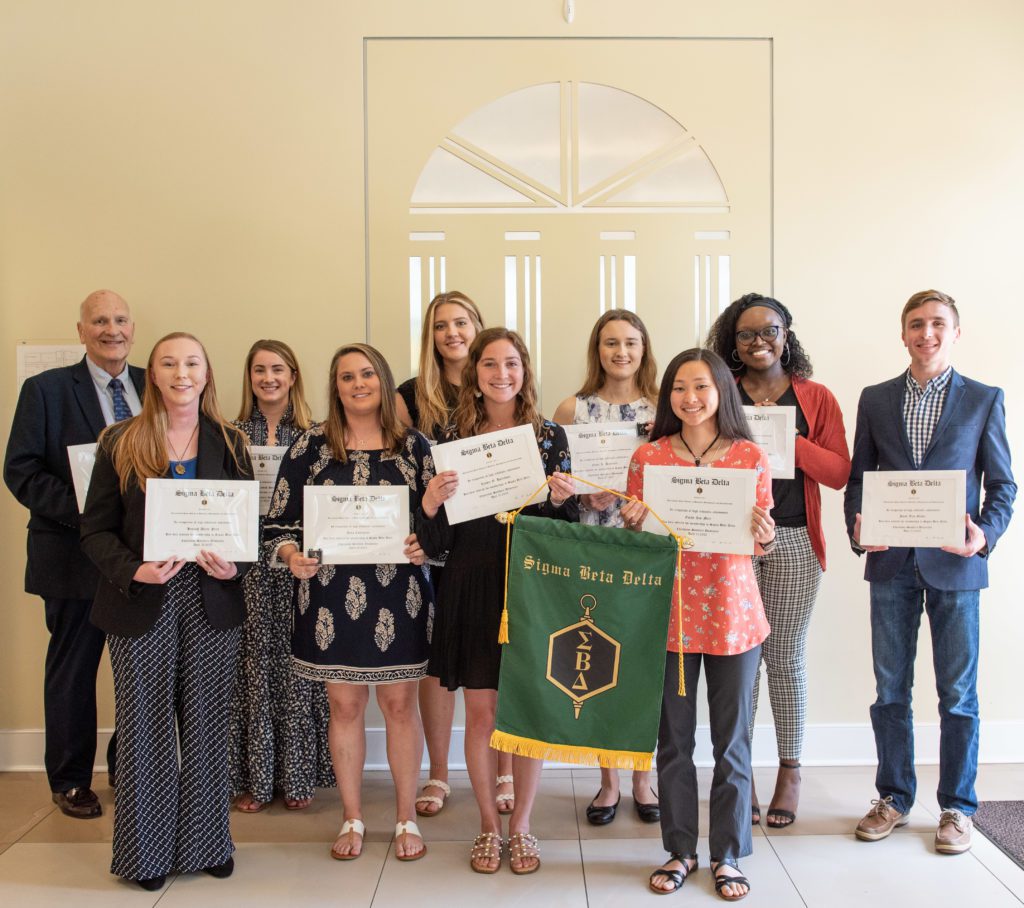 Mutliple people receiving their Sigma Beta Delta diploma