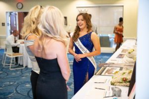 Miss CSU welcomes guests to the silent auction to raise funds for graphic design and art