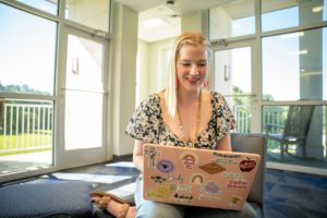 A girl sitting on a chair with her computer