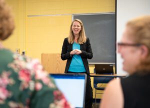 A woman explaining in a classroom something to other people