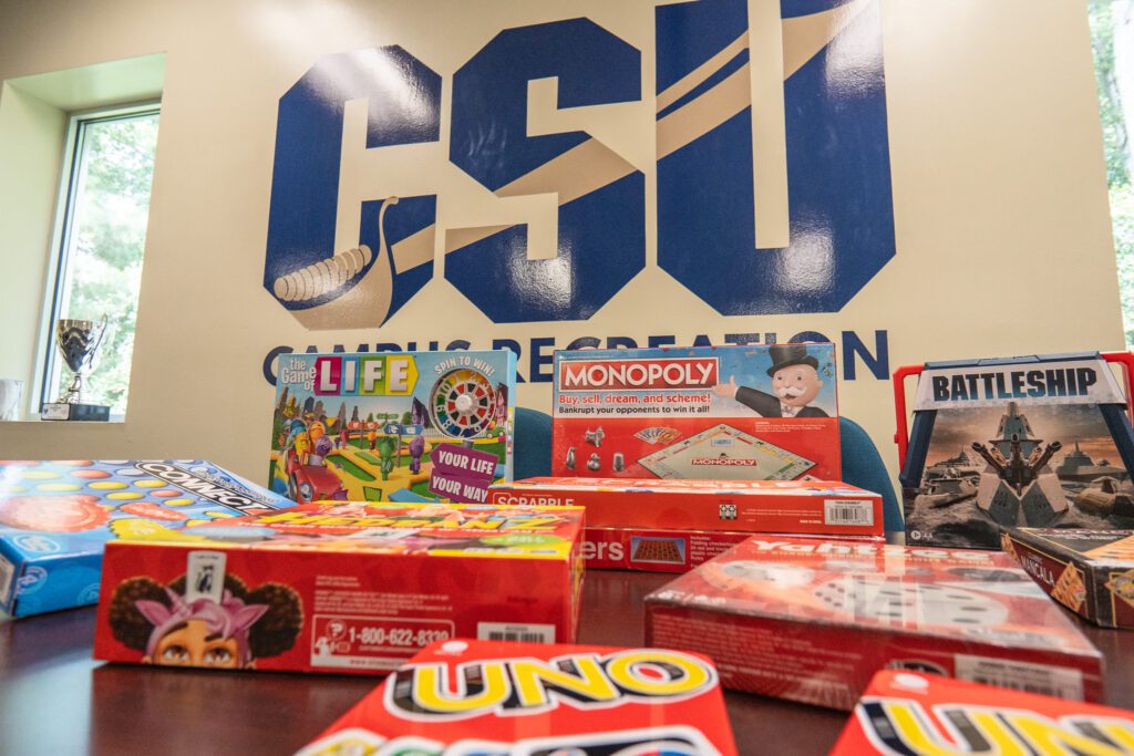 In the Brewer center there are multiple games on a table such as UNO and Monopoly.