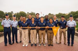 People from the ROTC team taking a picture in front of the point. The front row are holding a yellow flag stick
