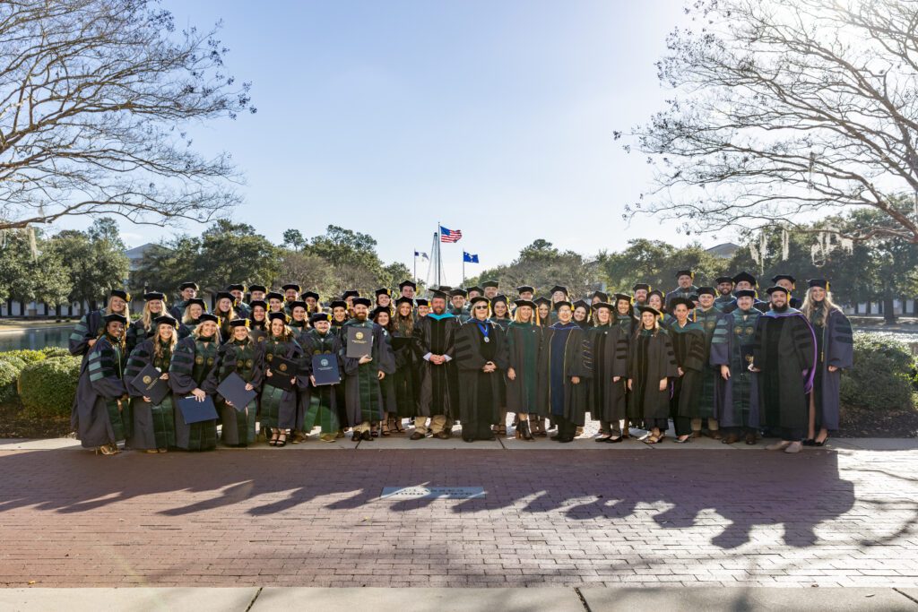 The inaugural class poses for a photo outside of Lightsey Chapel by the Reflection Pond at CSU