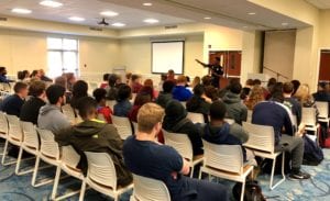 Reggie Burgess speaking to a room of college students.