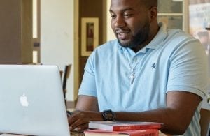 A graduate student studying on a laptop in Java City cafe.