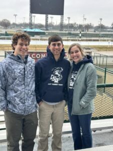 Two boys and one girl from the Clay Target Team smiling for a group picture.