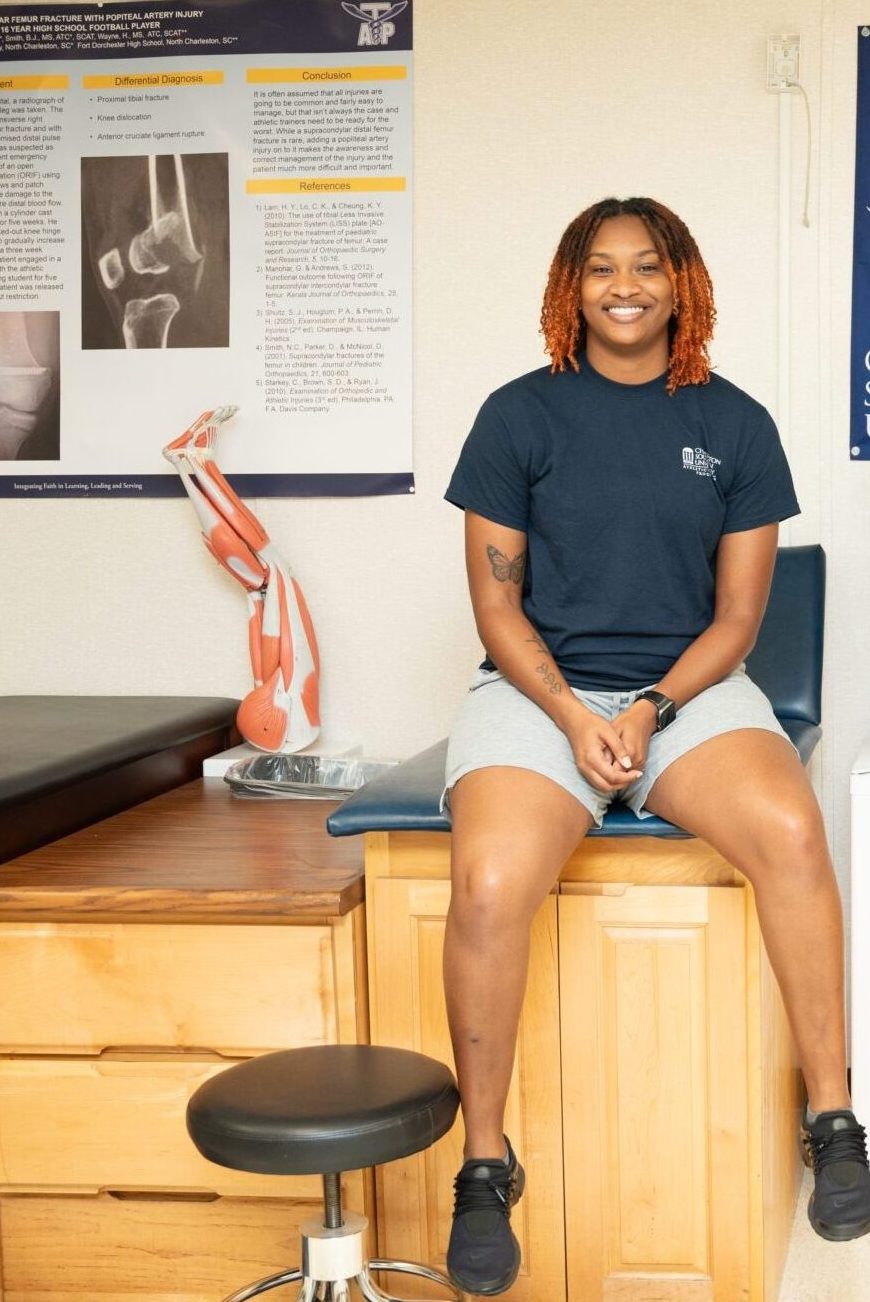 A girl sitting on a table in the athletic training room