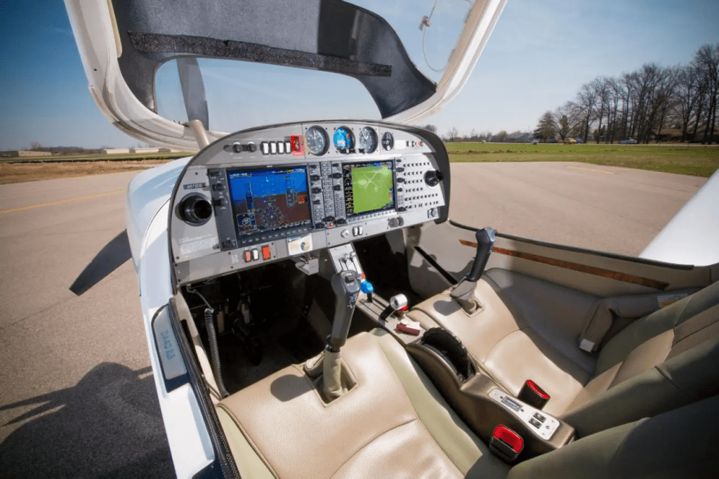 Interior of a small, two-seater plane showing the control panels and seats