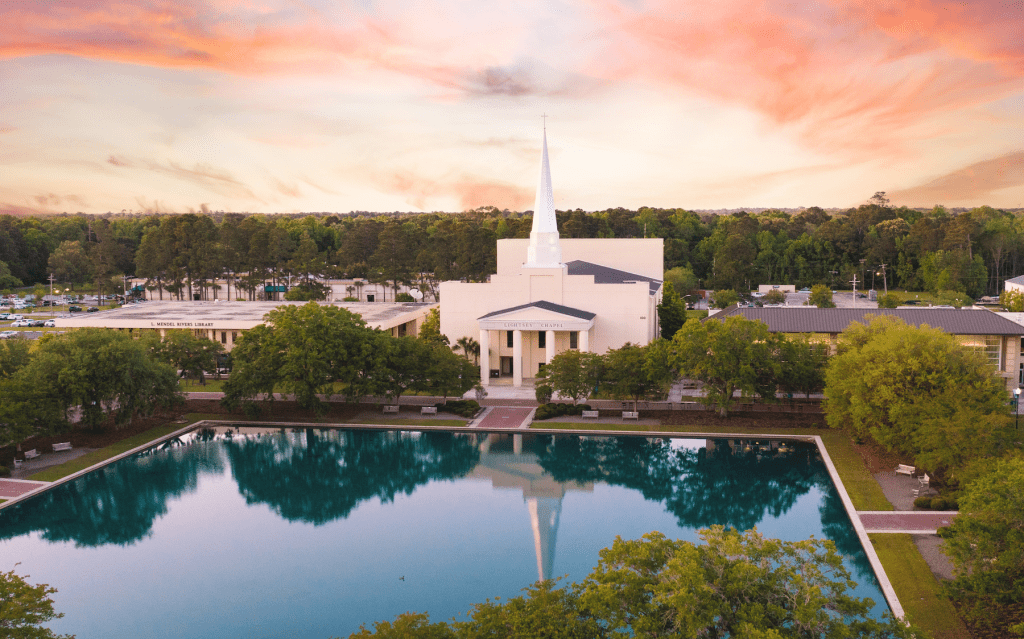 Aerial image of CSU's chapel and pond against a pink morning sky