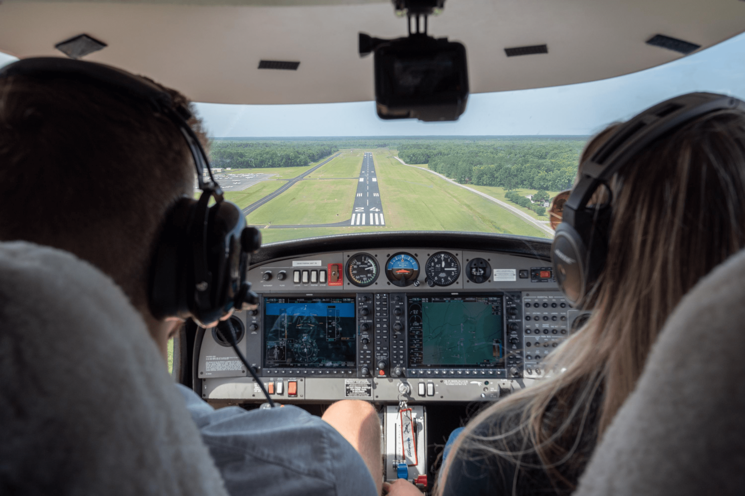 Interior of a small plane control panel with a pilot and co-pilot in their seats