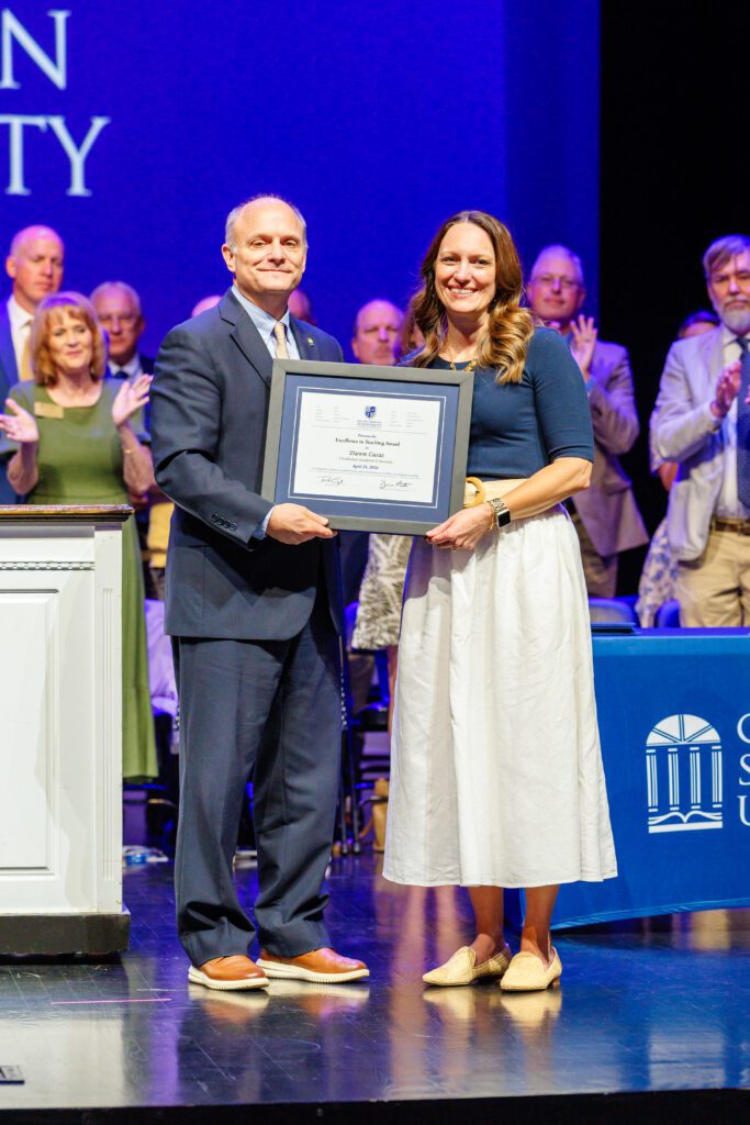 Provost Michael Wilder presents the Excellence in Teaching Award to Dr. Dawn Casas at commencement