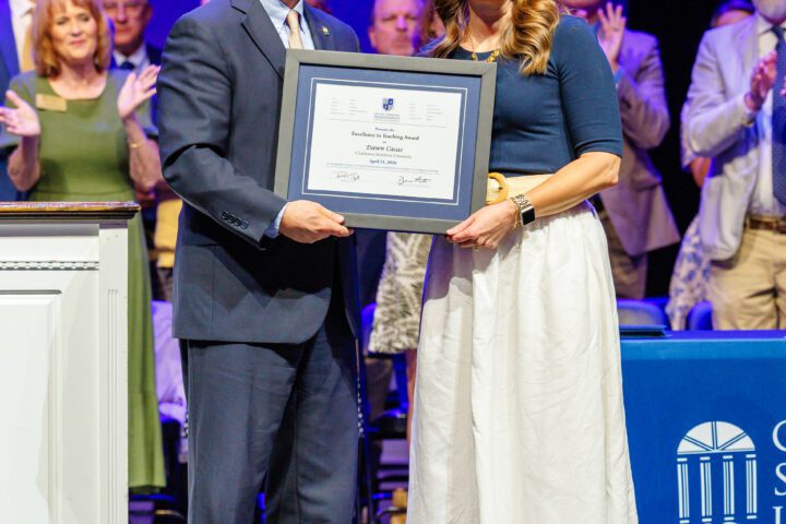 Provost Michael Wilder presents the Excellence in Teaching Award to Dr. Dawn Casas at commencement