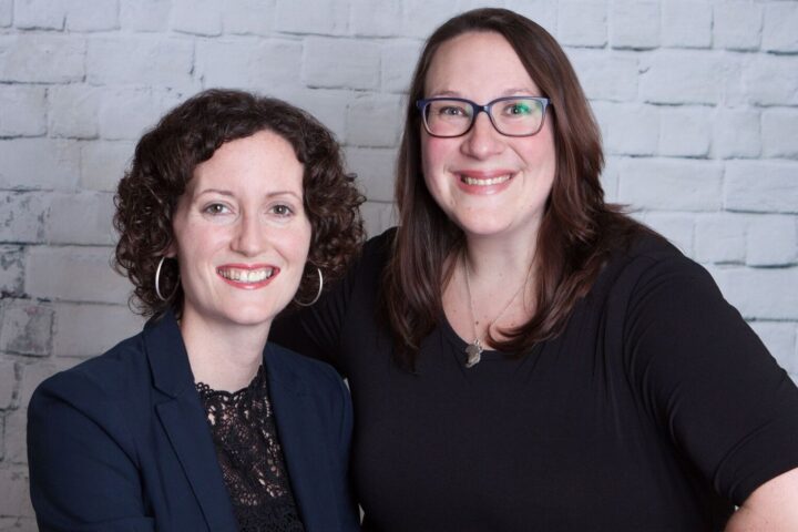 Dr. Hinson and Dr. Donnelly smiling on the picture, a white wall in the background