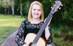 Holly Slice poses with a guitar in the park