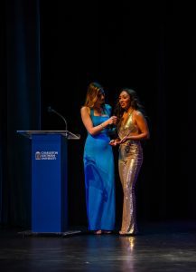 Two contestants stand on stage in pageant gowns during the Miss CSU event