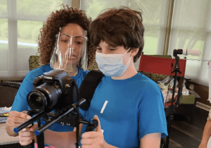 Ashley Drayton assists an artist at Camp Artism with videography