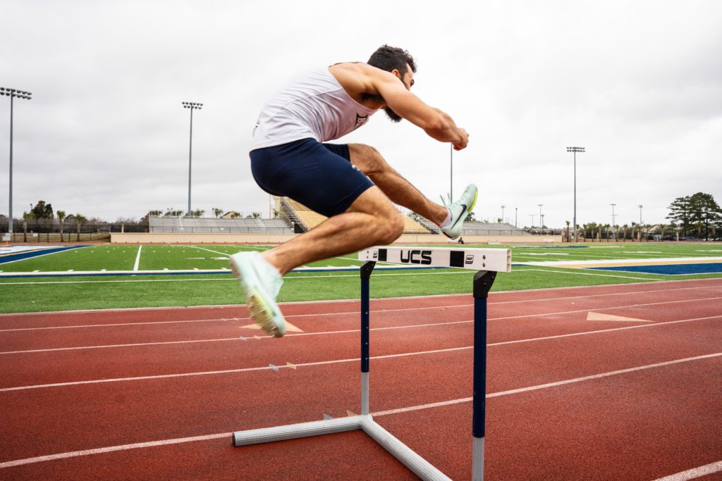 A boy jumping a hurdle