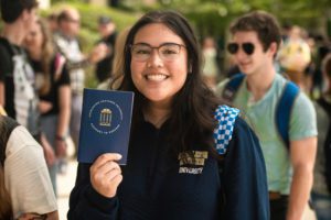 A girl holding a CSU passport- a newsletter graphic