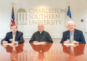 Luke Blackmon, CSU vice president for business affairs, the Rev. Rob Dewey, and Dr. Ron Harvell sign the agreement with ICISF.