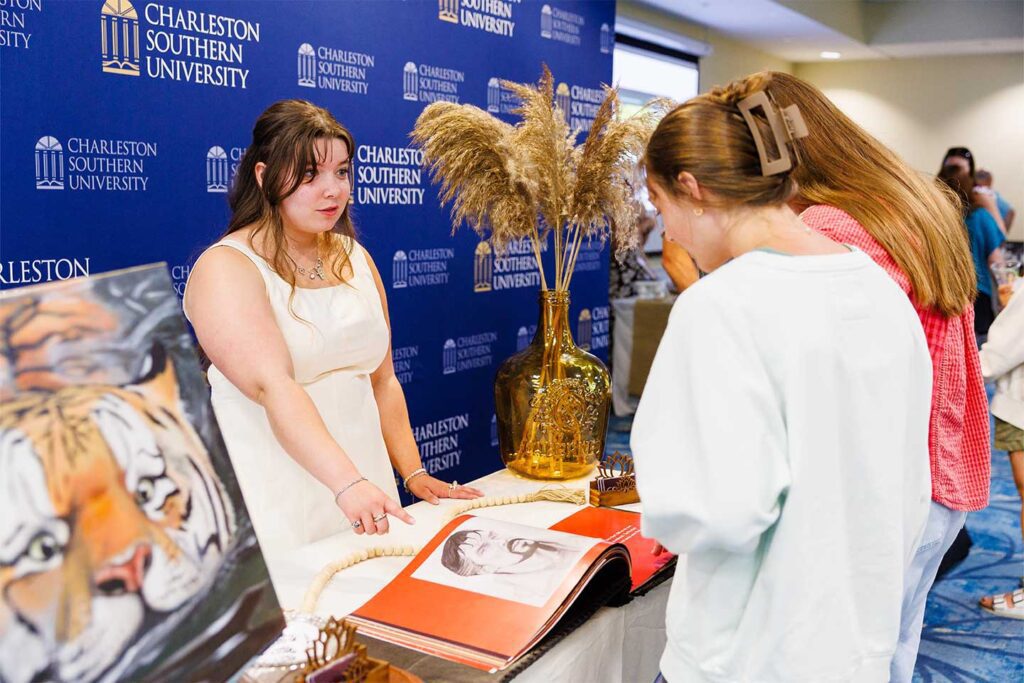 Graphic design student showcasing her portfolio at Charleston Southern University.